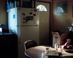 a person sitting at a table in front of a refrigerator