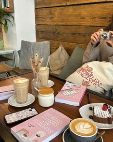 a woman sitting at a table with coffee, cake and other items on the table