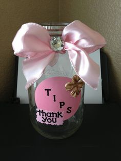 a mason jar with a pink bow on it and the words tips thank you written on it