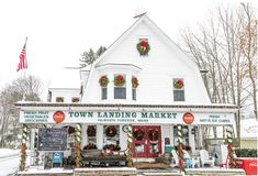 the town landing market is decorated with christmas wreaths and garlands on its front porch