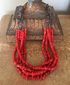 Put a little "wow" around your Neck with this 5-Strand Bamboo Coral Heishi Necklace. The Coral is taken up a notch by virtue of its chunky cut and vibrant color. The stones are graduated, ranging in diameter from 5mm to 17mm, and are fashioned in an array of shapes and heights. A rare cut for a look that is both sophisticated and eye-catching. We've paired the 5 strands of Coral with Violet Olive Shell Heishi, which is a wonderful color blend of dark brown and white. The Shell Heishi is added to Heishi Necklace, Bamboo Coral, Southwest Design, Toggle Clasp, Color Blending, Strand Necklace, Violet, Coral, Shells