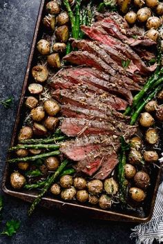 steak and asparagus with potatoes on a baking sheet, ready to be served