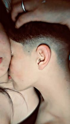 a man and woman kissing each other with their heads close to one another's foreheads