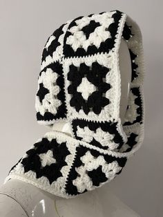 a black and white crocheted hat on top of a mannequin