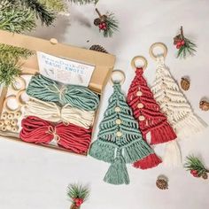 three christmas tree ornaments are in a box