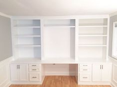 an empty room with white built in cabinets and wood flooring, along with hard wood floors