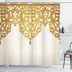 a white and gold shower curtain with an ornate design on the bottom, in a bathroom