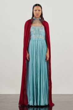 Blue gown featuring hand-embroidered glass yarn yoke with a pleated waistline. Comes with a contrasting maroon cape.
Components: 2
Pattern: Trimmed
Neckline: Cape: High Collar
Sleeve Type: Cape: Long Draped
Fabric: Organza (100% Silk) + Glass Yarn (100% TPU)
Lining-Satin (66% Viscose 34% Modal) 
Color: Blue,Maroon
Other Details: 
Glass yarn details
Sleeveless gown
Pleated waist
Occasion: 
Cocktail,Party - Aza Fashions Cape For Women, Long Drapes, Sleeveless Gown, Draped Top, Blue Gown, Ladies Gown, Gowns Online, Bell Bottom Pants, Draped Fabric