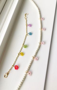 the necklace is decorated with multicolored glass beads and gold - plated chain