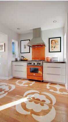 an orange stove top oven sitting inside of a kitchen