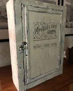 an old white wooden cabinet sitting on top of a table