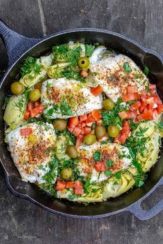 an iron skillet filled with food on top of a wooden table