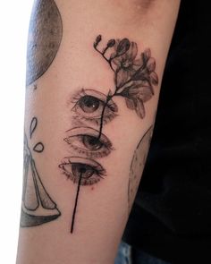 a close up of a person's arm with a flower and an eye on it