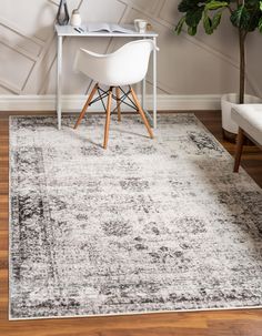 a white and black area rug with a wooden table in the corner next to it