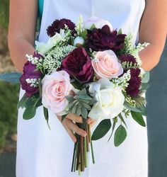 a woman holding a bouquet of flowers in her hands