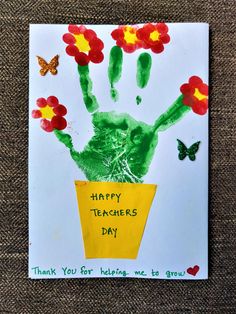 a child's handprint on a card with flowers in a flower pot and a butterfly