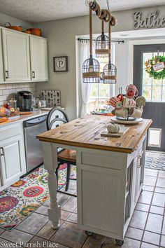 the kitchen island is made from wood and has birdcages on top of it