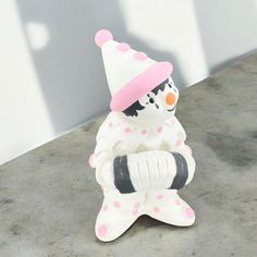 a ceramic figurine with a pink hat and polka dots on it's body