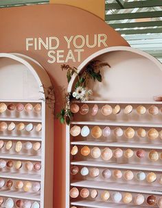 the wall is filled with lots of different types of doughnuts and there's a sign that says find your seat