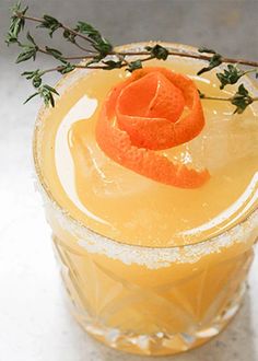 a drink with orange garnish on the rim