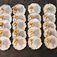 some white and gold decorated cookies on a black tablecloth with words written in them