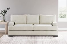 a white couch sitting on top of a rug in a living room