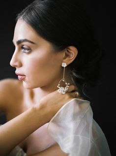 a woman in a white dress wearing earrings