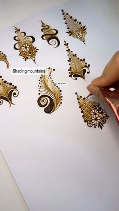 someone is doing something with gold on white paper