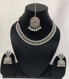 This is a beautifully designed Necklace set in SILVER  colour stones and beads, at the back of the necklace is a silver colour string to hold it tight around the neck, this is a light weight jewellery set, suitable to wear on all wedding and party occasions. We deliver worldwide Silver Kundan Jhumkas For Party, Festive Silver Jewelry Sets With Stone Work, Silver Bollywood Tikka With Meenakari, Silver Sets With Mirror Work For Celebration, Silver Kundan Jewelry Sets With Latkans, Heavy Silver Tikka For Festive Occasions, Silver Chandbali Necklace With Mirror Work, Silver Party Jewelry With Mirror Work, Hand Set Silver Jhumkas For Party