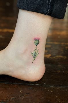 a small flower tattoo on the ankle