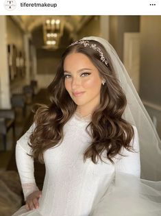 a woman in a wedding dress posing for a photo with her hair down and wearing a veil