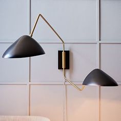 two black lamps are hanging on the wall