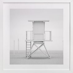 a black and white photo of a lifeguard chair in the middle of an empty room