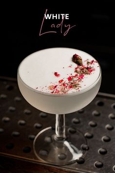 the white lady cocktail is garnished with rose petals and crumbled on top