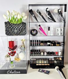 a display case filled with lots of beauty products and flowers next to a vase full of tulips