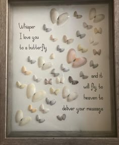 a shadow frame with shells and words written on the inside, in front of a white background