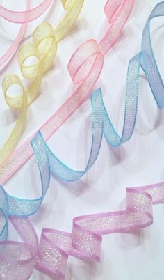 several different colored ribbons on a white surface