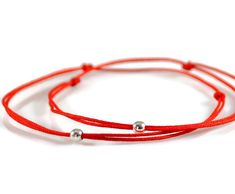 Set of Two Red String Bracelets * Evil Eye Bracelets * Couples Bracelets * Friendship Gift * Wear for protection against the evil eye and negative energy. * It is believed that the left side of the body is the receiving side, so wearing it on the left wrist allows the receiving of good fortune. D E T A I L S ----------------- This listing is for TWO bracelets, they are made of red 0.5mm nylon cord with a tiny 3mm sterling silver bead. C L O S U R E _ O P T I O N S ------------------------------- Red Round Beads Bracelet As Gift, Handmade Adjustable Red Wrap Bracelet, Adjustable Red Handmade Wrap Bracelet, Red Friendship Bracelets With Sliding Knot, Red Bracelet With Sliding Knot For Valentine's Day, Red Sliding Knot Bracelet For Valentine's Day, Red Round Jewelry For Friendship, Round Red Jewelry For Friendship, Adjustable Red Bracelets With Round Beads