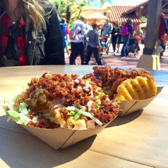 a close up of a basket of food on a table with people in the background