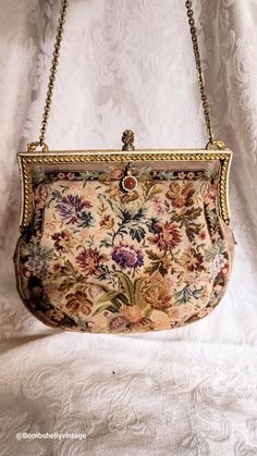 This beautiful little purse is from the Victorian era. Fabulous condition with no holes or obvisous stains. Pretty gold tone frame with an elegant knot like clasp.  Dangling from one side of the bag is a carnelian cabachon jewel. Very clean inside.  The floral needlework is intricate and so pretty in shades of plums and golds. It comes with a metallic gold leather coin purse and a mirror covered in silk.  As you can see from the picture, the mirror has some damage on the underside of it and the silk shows a lot of wear.  Please see all the photos for details and measurements below.  All sales are final. Measurements 8"widex 7" tall 8" chain Vintage Gold Shoulder Bag With Gold-tone Hardware, Classic Gold Shoulder Bag As Gift, Classic Gold Shoulder Bag For Gift, Vintage Gold Shoulder Bag, Vintage Gold Shoulder Bag For Formal Occasions, Classic Gold Evening Bag As Gift, Classic Gold Evening Bag For Gift, Vintage Gold Pouch Shoulder Bag, Vintage Handmade Gold Coin Purse