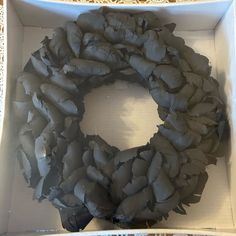 a white box with a wreath made out of clay in it's bottom half