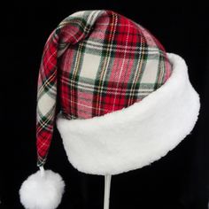 "This festive novel Santa Claus hat is made up in a red multicolor plaid flannel fabric. The fabric is a heavier weight quality cotton flannel shirting fabric, cozy and warm. The hat is accented with snowy white soft Sherpa faux fur fabric trim. Proportions of the hat are generous and will fit most head sizes, ladies or gents. The styling is a traditional Santa slouch stocking style cap. Measurement for opening for your head is 24-25\" circumference and the length is 19\". There is a snowy white Adjustable Christmas Cap, Adjustable Brimmed Hat For Holiday, Adjustable Mini Christmas Hats, Adjustable Christmas Costume Hats And Headpieces, White Christmas Cap, Santa Costume, Holiday Hats, Santa Claus Hat, Shirting Fabric