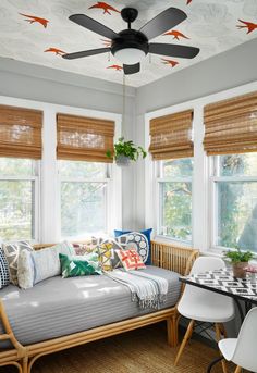 a living room filled with lots of furniture and windows covered in blinds on top of them