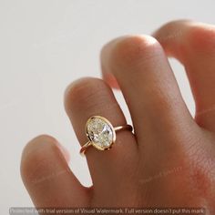 a woman's hand with a ring on it that has a diamond in the middle