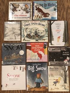 there are many children's books laid out on the wooden table together, including snow