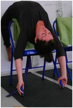 a man is doing a handstand on a chair while holding a pair of scissors