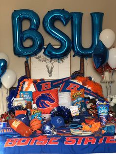 the bed is decorated with blue and orange balloons, streamers, and other sports related items