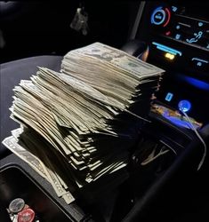 a pile of money sitting on top of a car dashboard