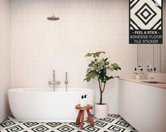 a white bath tub sitting next to a wooden stool in a bathroom with black and white tiles