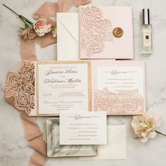 the wedding stationery is laid out on a marble table